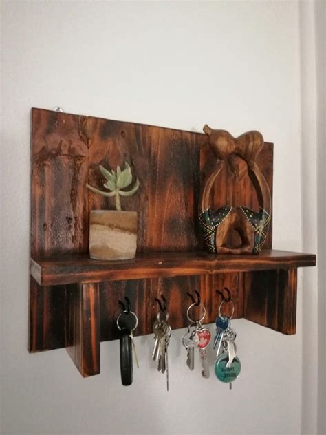 A Wooden Shelf With Key Hooks And Other Items On The Top Hanging From