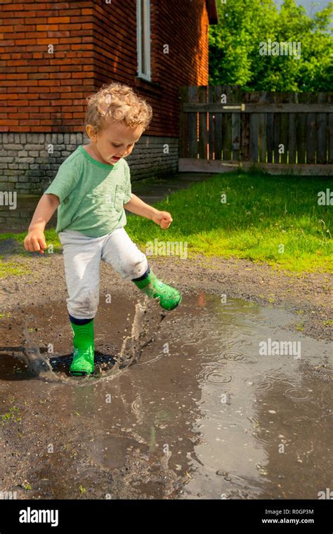 Boy Playing In Puddle Stock Photo Alamy