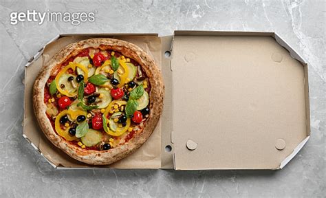 Tasty Vegetable Pizza In Cardboard Box On Light Grey Table Top View