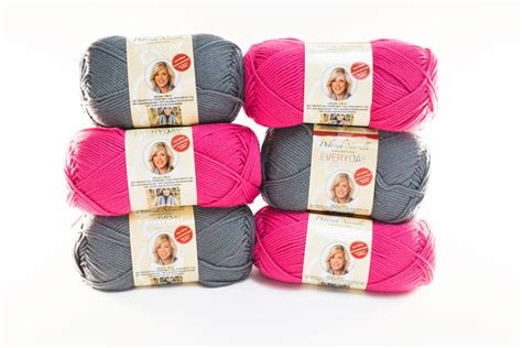 Four Skeins Of Pink And Grey Yarn Are Stacked On Top Of Each Other