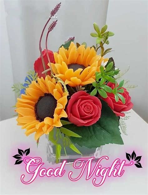 A Vase Filled With Sunflowers And Roses On Top Of A Table