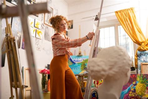 Artist Having Inspiration Painting On Canvas Standing Near Window Stock