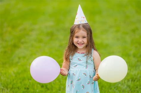 Belle Petite Fille En Robe Bleue Et Chapeau Avec Des Ballons Dans Le