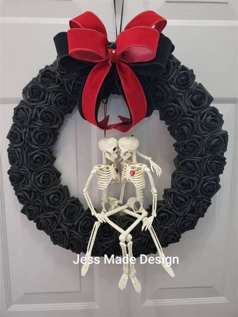 A Wreath With Two Skeletons Hanging From It S Side And A Red Bow On The Front Door