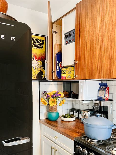 Walnut Cabinets Hide An Immovable Eyesore Alongside Cups And Plates In