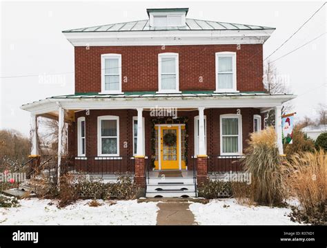 Old 1927 American Four Squares red brick with white trim house facade in late autumn, Quebec ...