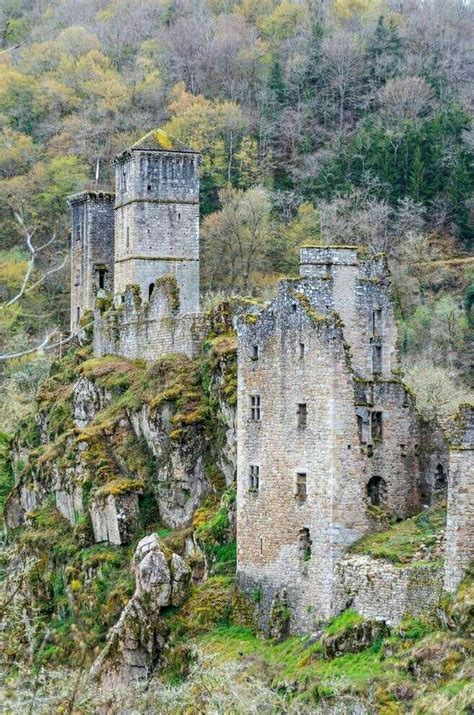 An Old Stone Castle Sitting On Top Of A Lush Green Hillside