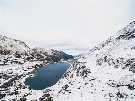 Lago cercado pelas montanhas tatra coberto de neve na polônia Foto Grátis