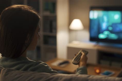 Premium Photo Woman Sitting On The Couch And Watching Tv