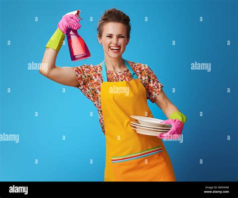 Happy Housewife In Orange Apron With Washed Plates Showing Dishwashing Detergent Isolated On