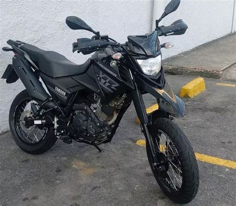 A Black Motorcycle Parked In Front Of A Building