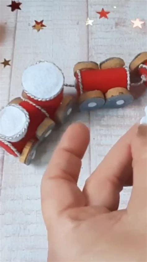 A Hand Is Holding A Piece Of Paper That Looks Like A Toy Train And Drums