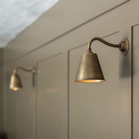 Three Lights Are On The Side Of A White Cabinet In A Room With Gray Walls