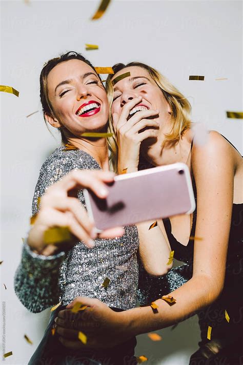 Two Women Taking A Selfie While Confetti Falls Around Them