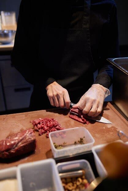 Chef Carnicero Cortando Carne De Cerdo Con Cuchillo En La Cocina