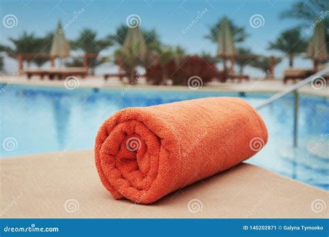 Orange Towel Lying On A Lounger Near The Swimming Hotel Pool Summer