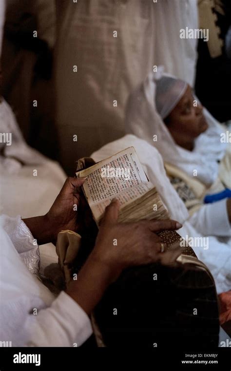 An Ethiopian Orthodox Christian pilgrim reading the bible in Amharic language during "Holy Fire ...