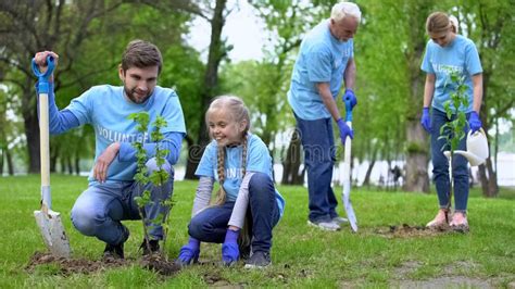 Felices Voluntarios Familia Plantando Ãrboles En El Exterior