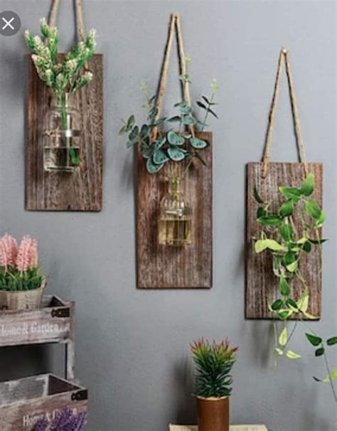 Three Hanging Planters With Plants In Them On The Wall Next To A Wooden