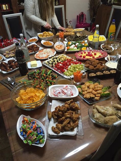 A Woman Standing In Front Of A Table Full Of Food