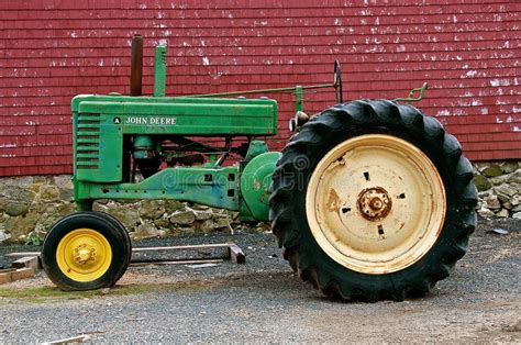 Old A John Deere Tractor Parked In Front Of A Red Barn Editorial