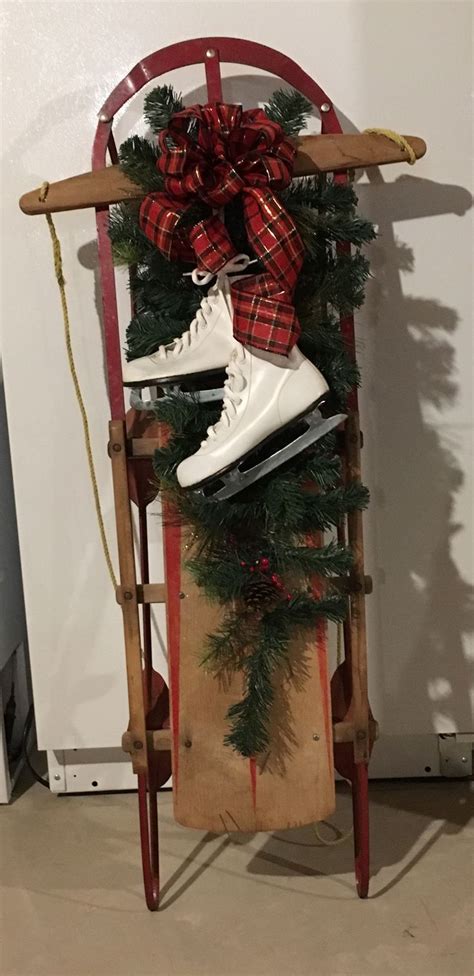 An Old Sled With Christmas Decorations And Skates On It Hanging From