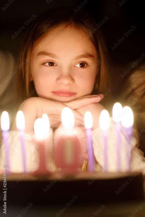 Cute Ten Years Old Girl Making A Wish Before Blowing Candles On Her