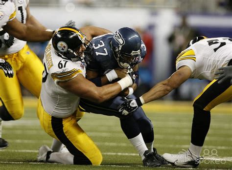 a football player is being tackled by two other players