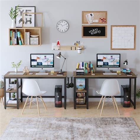 two computer desks with computers on them in front of a clock and bookshelf