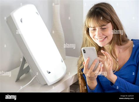 Woman smartphone light therapy Stock Photo - Alamy