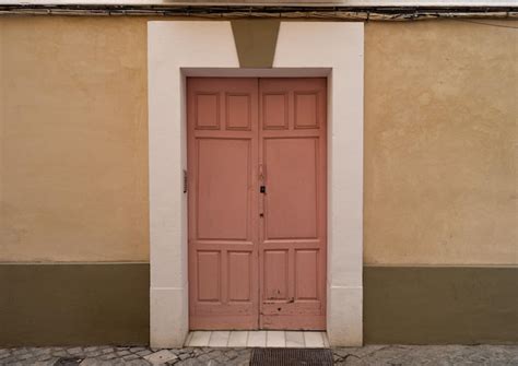 Foto de uma velha porta de madeira rosa em um prédio antigo Foto Grátis