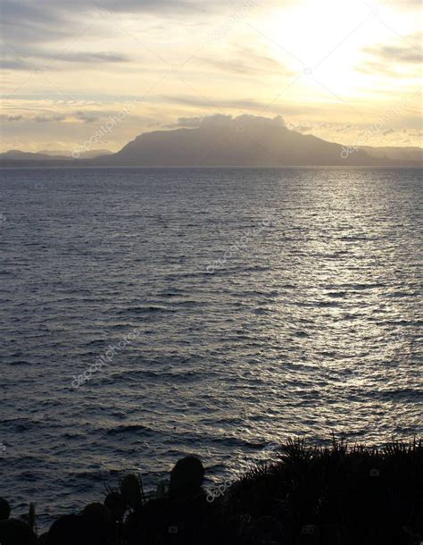 Evocadora Imagen De Puesta De Sol Sobre El Mar Con Silueta De Cabecera