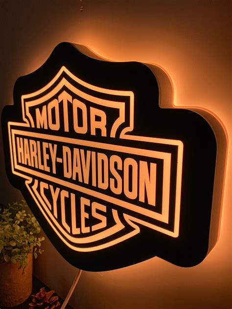 Harley Davidson Cycles Illuminated Sign On Wall Next To Potted Plant In