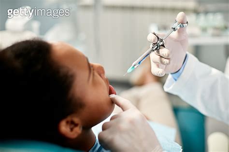 Close Up Of Dentist Giving Anesthetic To Black Female Patient During