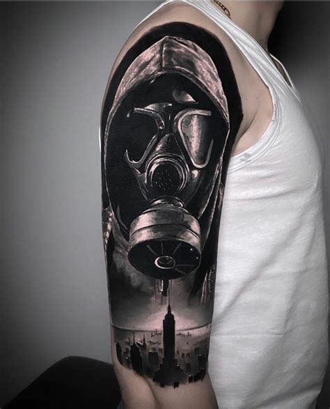 A Man With A Gas Mask Tattoo On His Arm Is Shown In Black And White