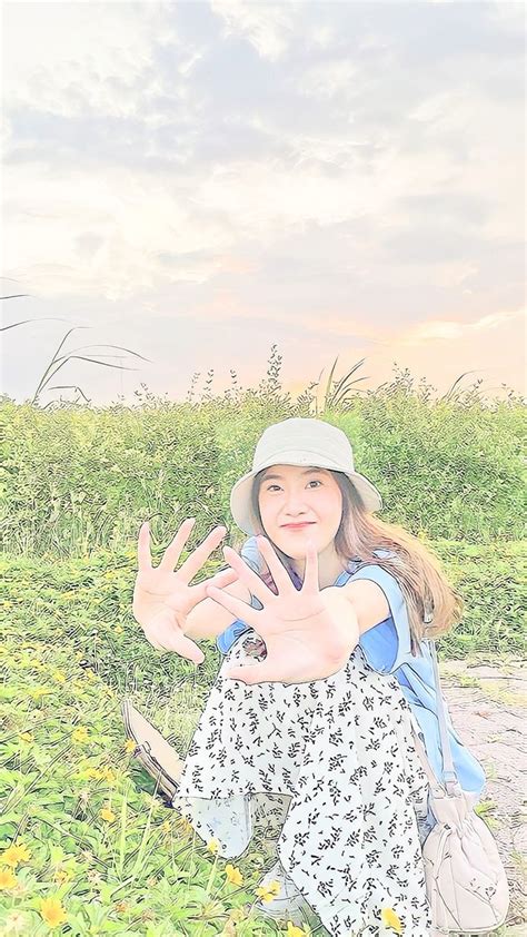 A Woman Sitting On The Ground With Her Hand Up In Front Of Her Face