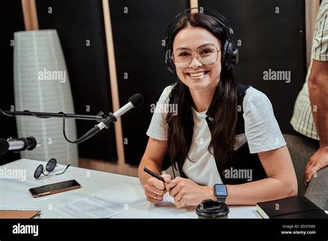 Portrait Of Happy Young Female Radio Host Smiling At Camera While