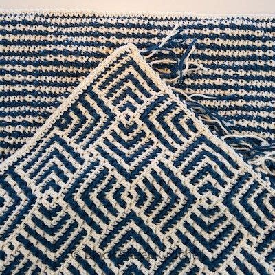 Two Blue And White Crocheted Rugs Sitting On Top Of Each Other