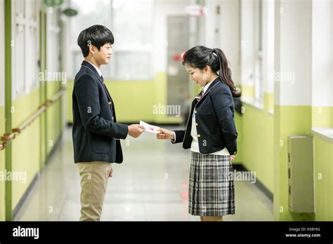 Side view of school boy and school girl passing a card at school Stock Photo - Alamy