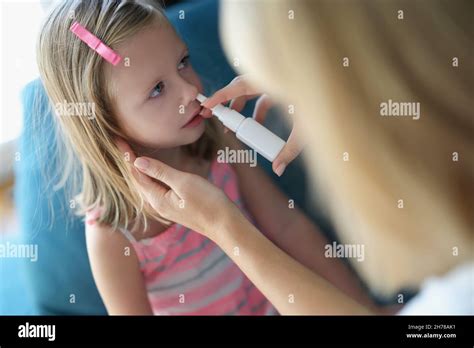 Mom Sprays The Baby S Nose With Spray Stock Photo Alamy