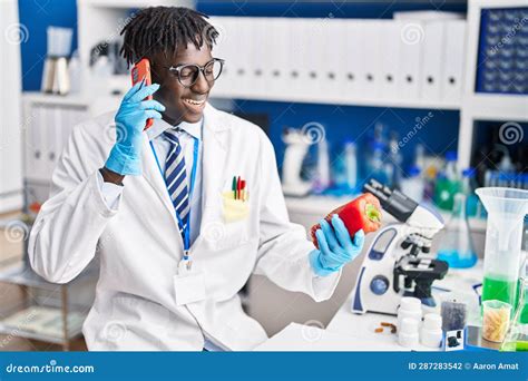 African American Man Scientist Talking On Smartphone Holding Pepper At