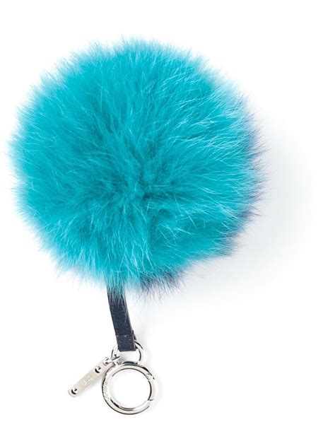 A Blue Furry Ball Keychain On A White Background