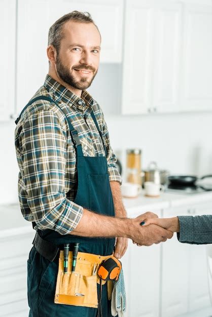 Premium Photo Smiling Handsome Plumber And Customer Shaking Hands In