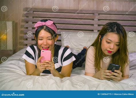 Young Happy And Pretty Asian Chinese Girlfriends Sitting At Home