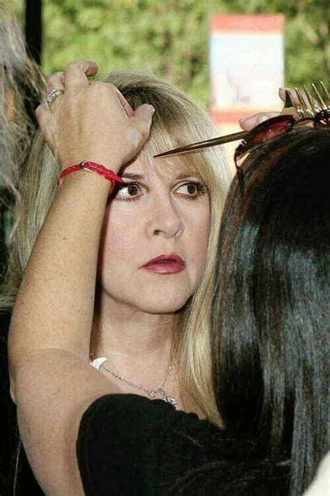 A Woman Getting Her Hair Combed By Another Woman With Scissors On Her