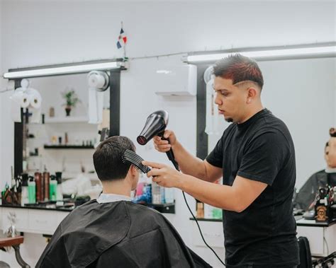 Cabeleireiro Secando O Cabelo De Seu Cliente Pente E Secador Foto