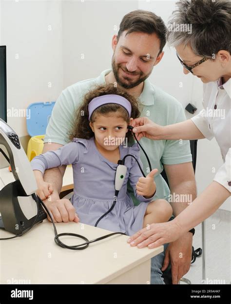 Child Hearing Test Doctor Audiologist Examineing Kids Ear And Assess