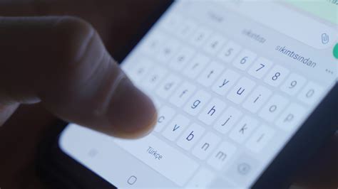 Typing a message from the close-up phone keyboard. Close-up of the
