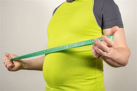 Un Homme Dans Les Jeans Et Un T Shirt Avec Un Gros Ventre Sur Un Fond