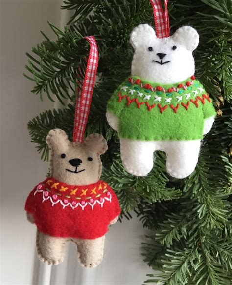 Two Teddy Bears Are Hanging From A Christmas Ornament On A Tree With